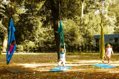 Kinder beim Aerial-Yoga in farbenfrohen Tüchern