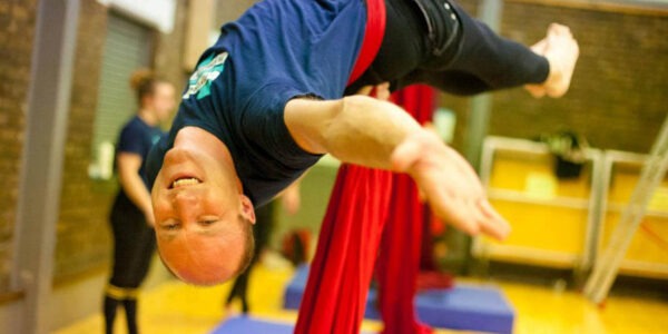 Chris Wigan praktiziert Aerial Yoga.