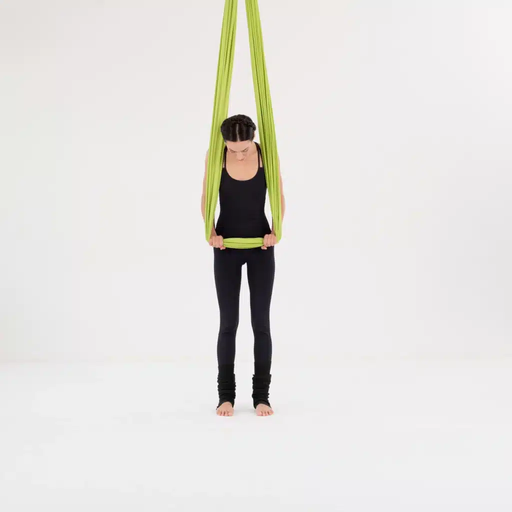 Fokus beim Aerial Yoga Training: Detailansicht der Tuchhöhe-Einstellung mit grünem Yoga-Hängematten-Tuch in einem Berliner Studio.