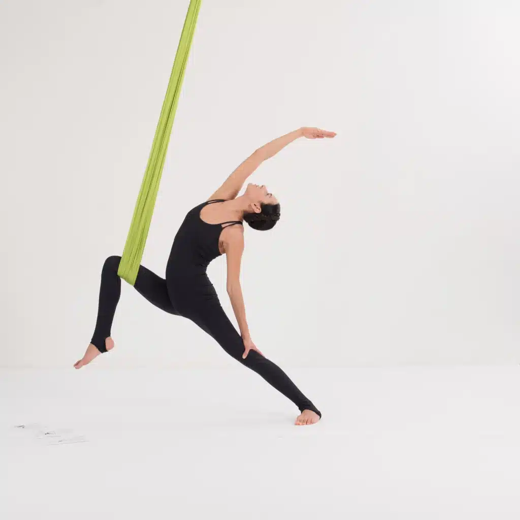 Aerial Yoga friedvoller Krieger im Tuch mit geöffneter Brust und Rückbeuge zur Mobilisierung der Flanken.