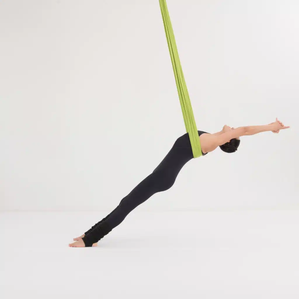 Aerial Yoga Rückwärtsbrett im Aerial Yoga Tuch. Frau lehnt sich nach hinten und streckt den Körper für eine intensive Öffnung von Brust, Schultern und Rücken.