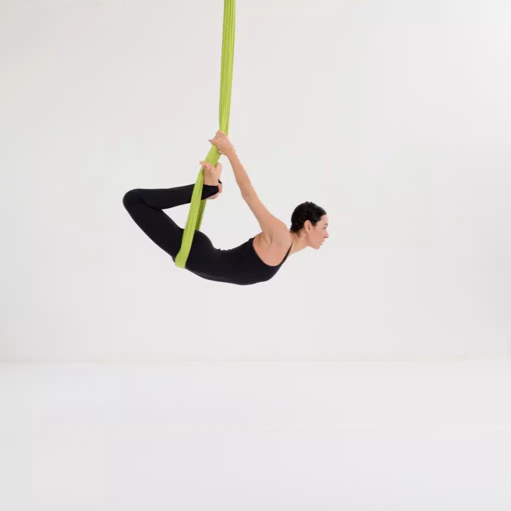 Aerial Yoga Vogel Pose im Tuch mit Rückbeuge zur Aktivierung der Rückenmuskulatur und Öffnung der Brust.